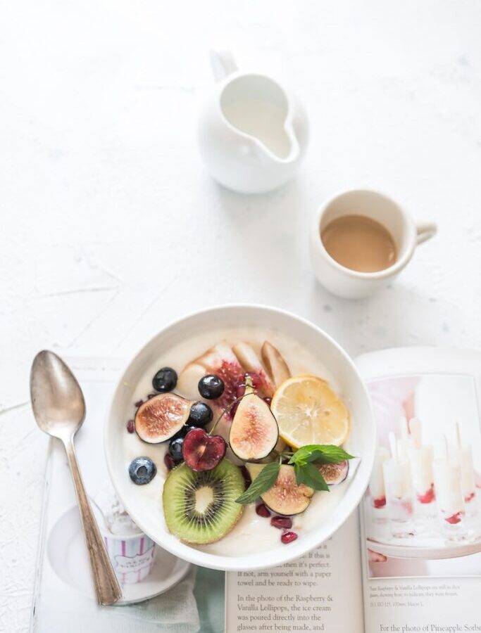 white ceramic plate beside gray steel spoon
