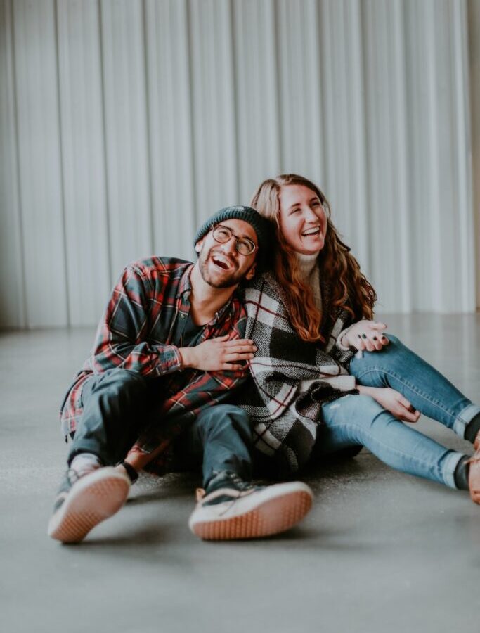 smiling woman and man sitting on floor