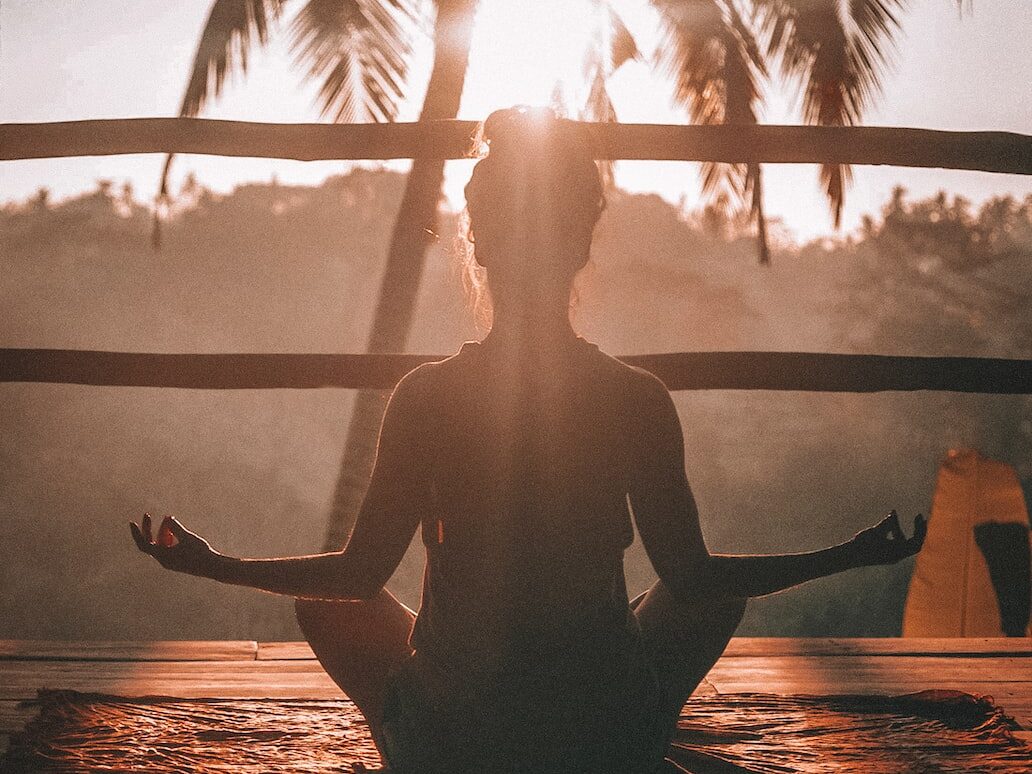 woman doing yoga meditation on brown parquet flooring