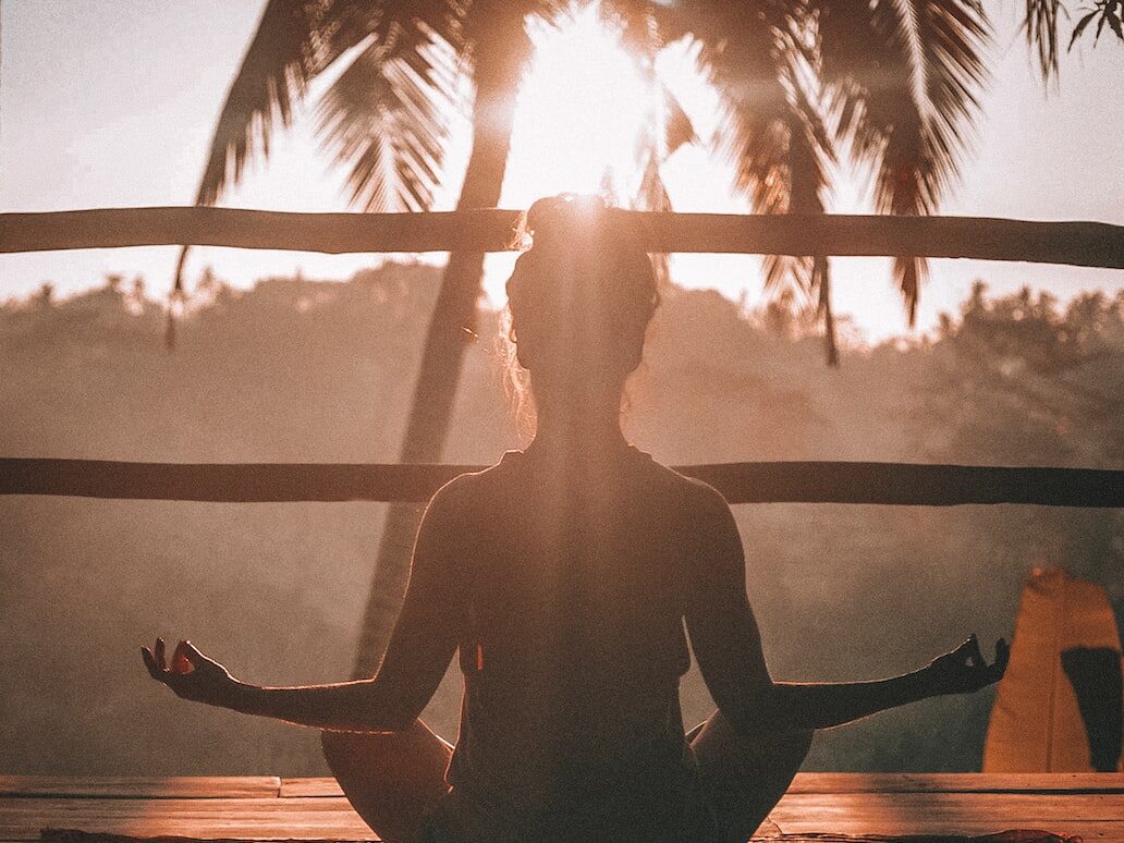 woman doing yoga meditation on brown parquet flooring