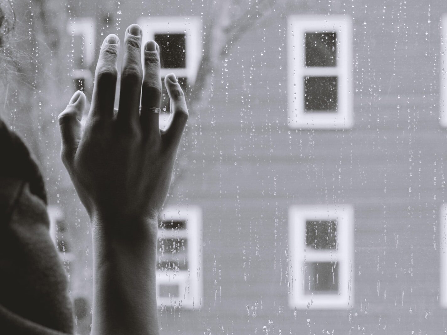 grayscale photo of woman right hand on glass