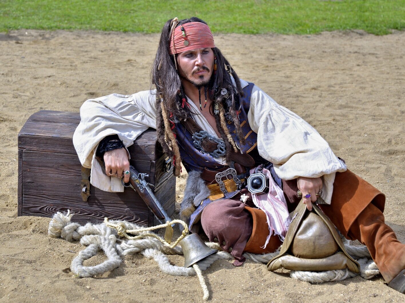 man in brown jacket and red cap sitting on brown horse during daytime