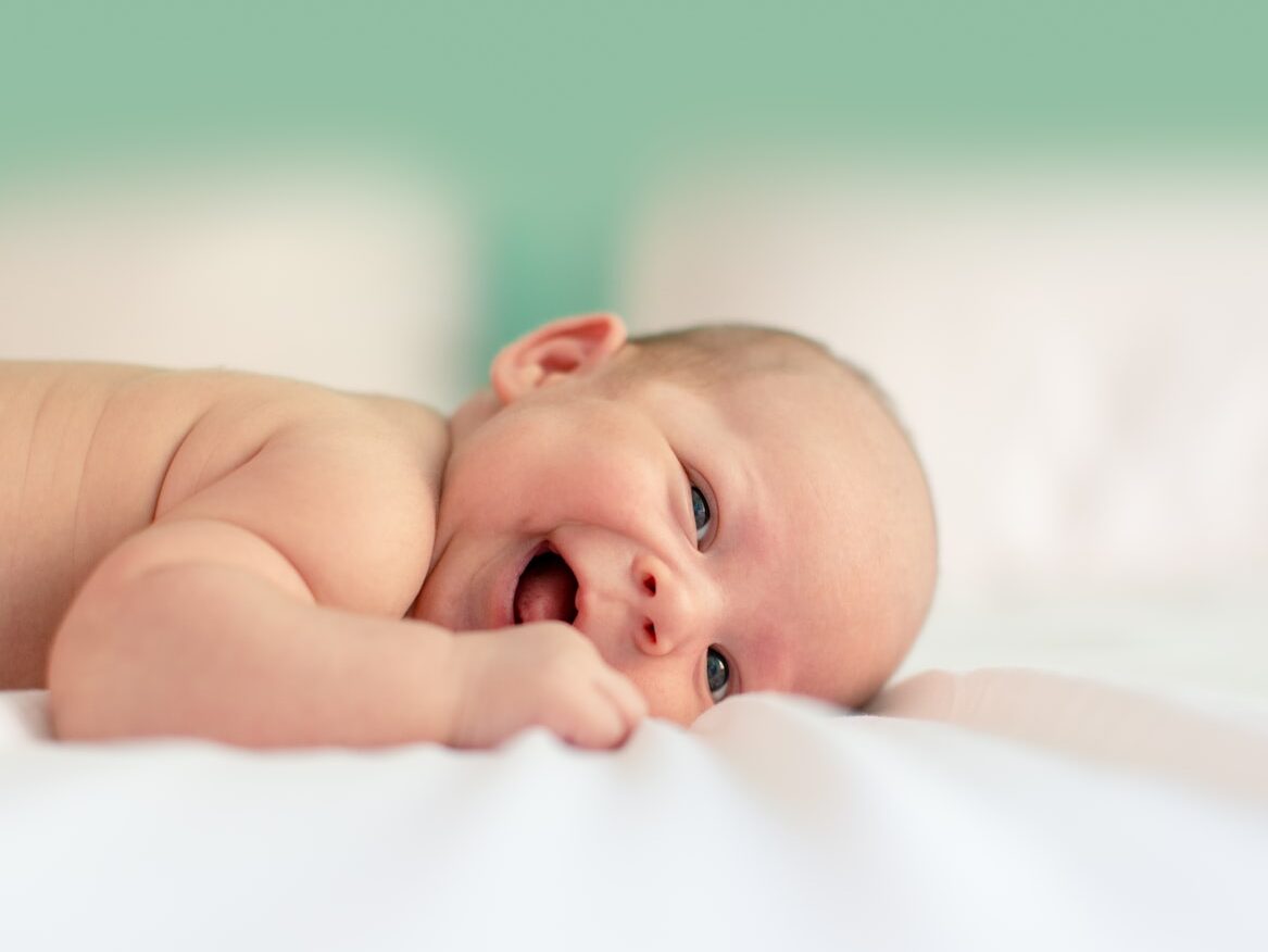 baby lying on fabric cloth