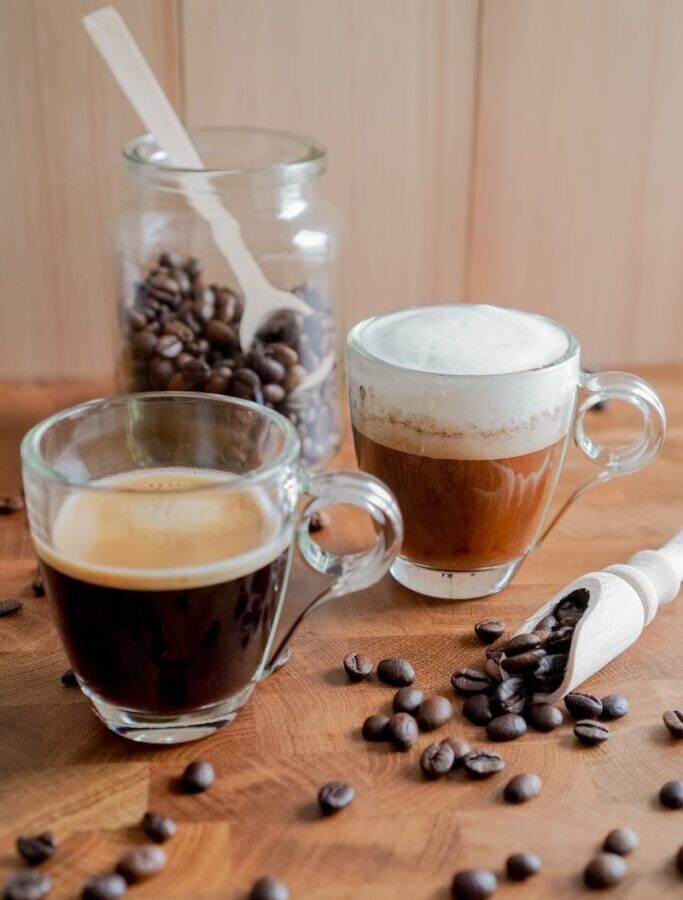 clear glass mug with coffee beans on brown wooden table