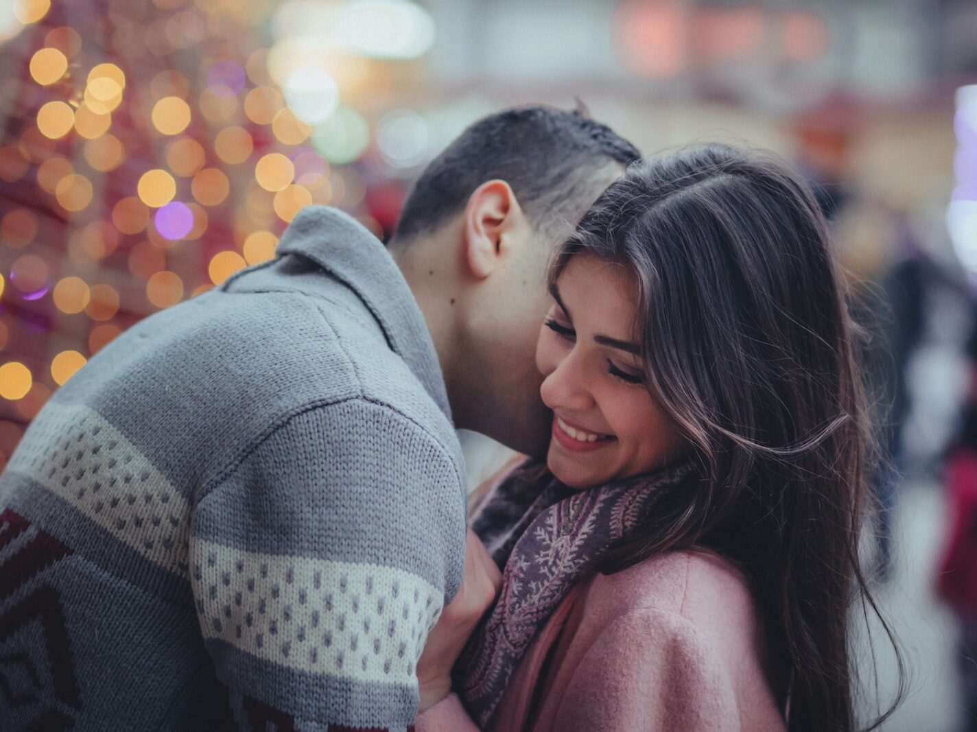 shallow photography of man hugging woman outdoors