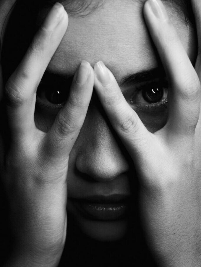 grayscale photo of woman covering her face