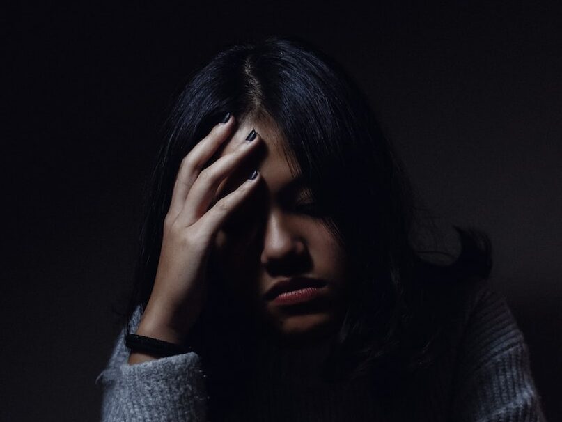 woman in gray sweater seating on chair