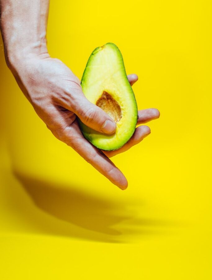 person holding green and yellow fruit