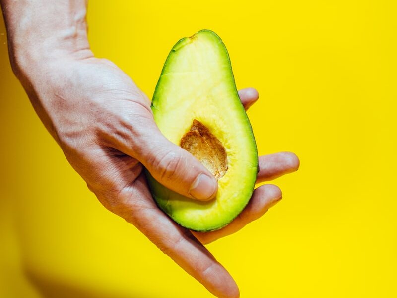 person holding green and yellow fruit