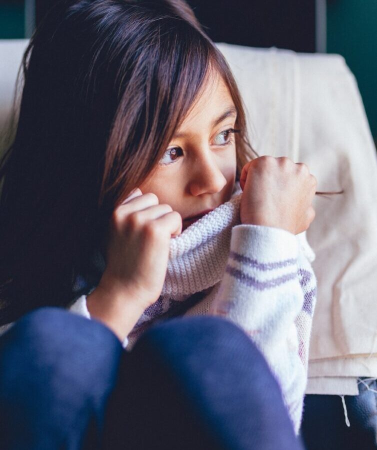 girl sitting on vehicle seat while looking at window