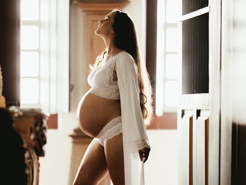 pregnant woman standing beside door
