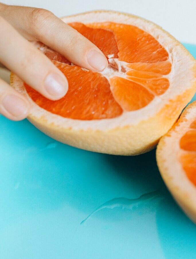 Person Touching Sliced Orange Fruit