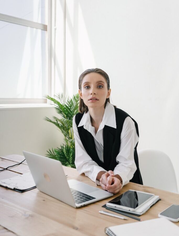 Woman Standing by the Table with Laptop