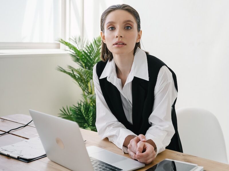 Woman Standing by the Table with Laptop