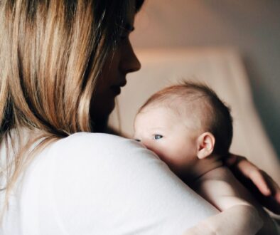 woman in white shirt carrying baby