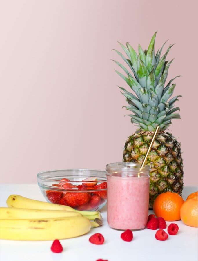 strawberry juice beside fruits on top of table