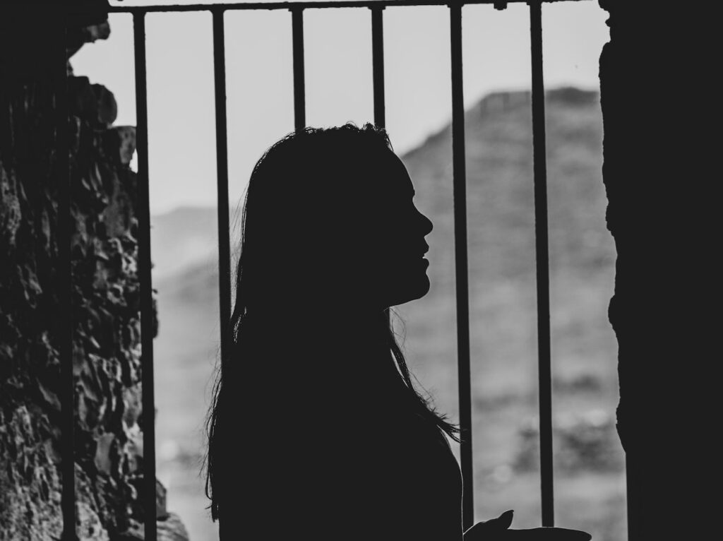 shadow of woman by the metal bar window