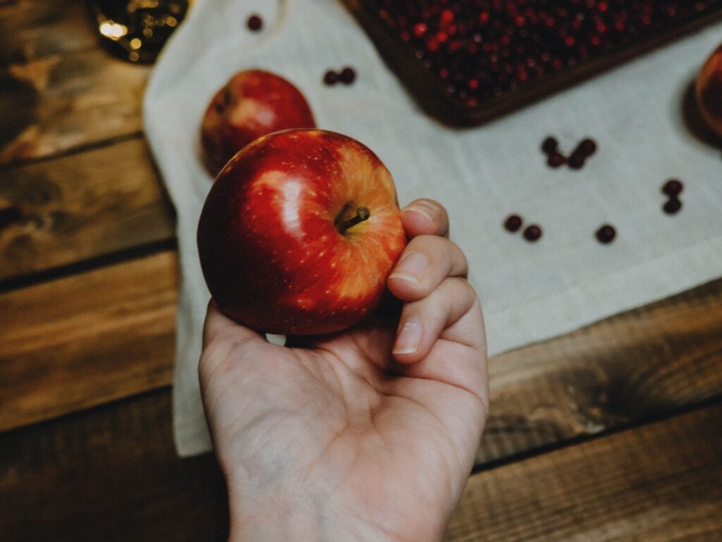 person holding red apple fruit