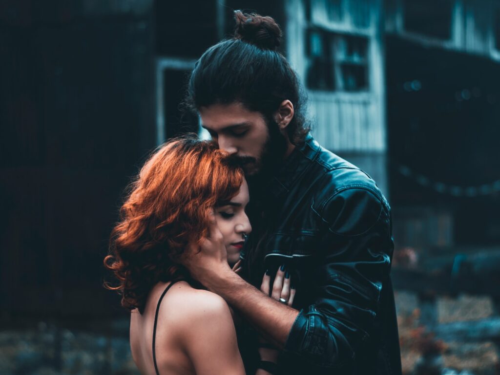 shallow focus photography of man and woman hugging