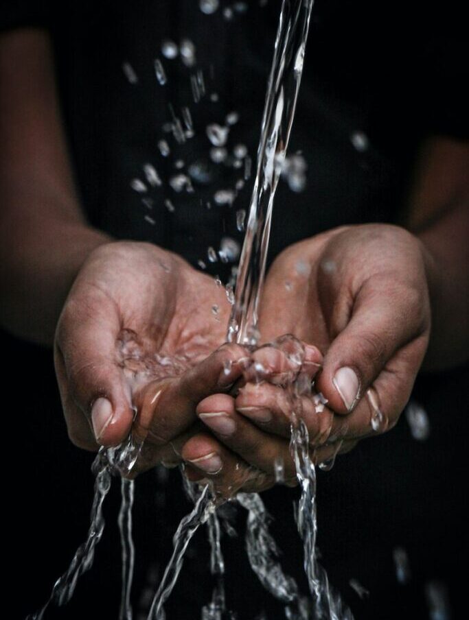 pouring water on person's hands
