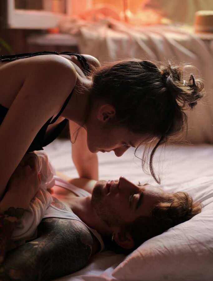 Woman in Black Tank Top Lying on Bed