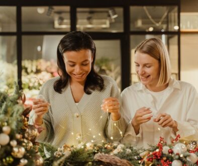Woman in White Long Sleeve Shirt Holding Bouquet of Flowers