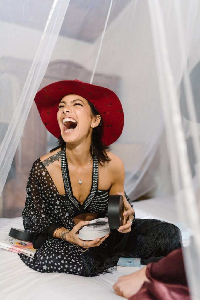 Woman in Black and White Floral Dress Wearing Red Hat