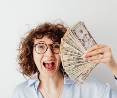 Happy Woman in Blue Long Sleeve Blouse Holding Money