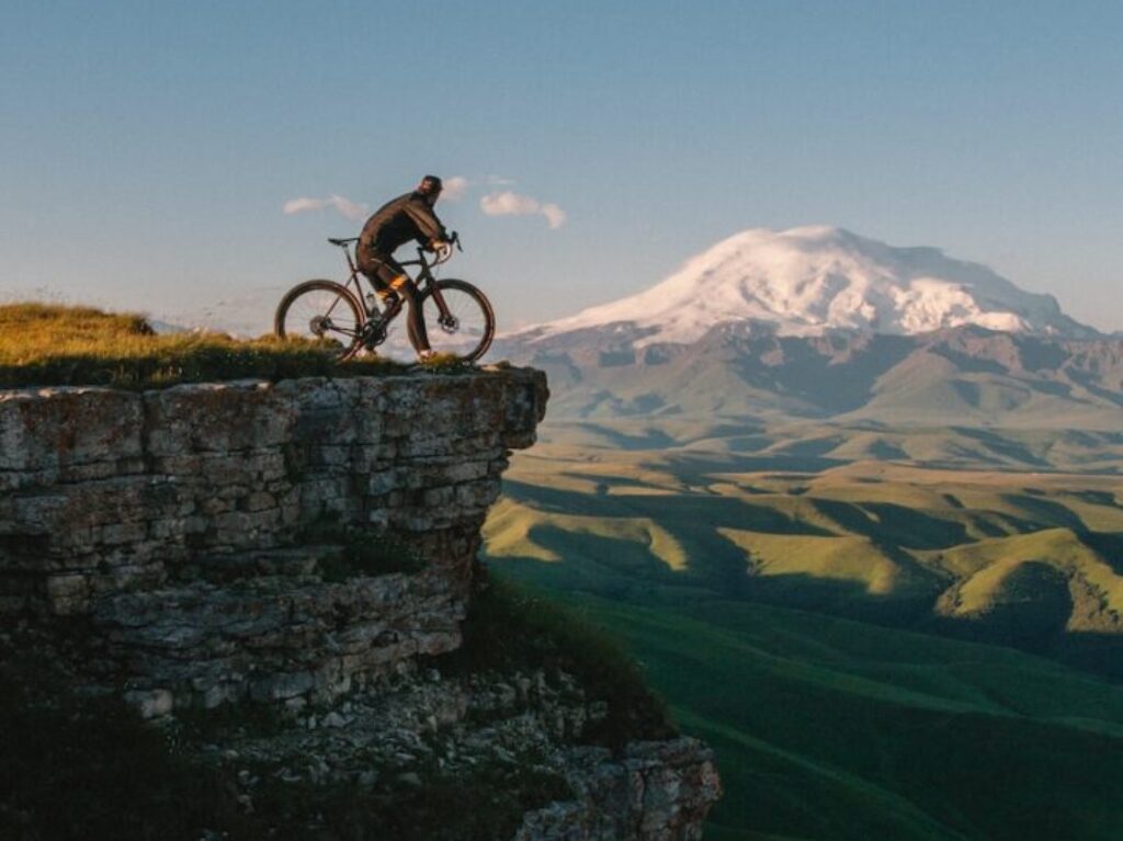 man riding bike on cliff at daytime