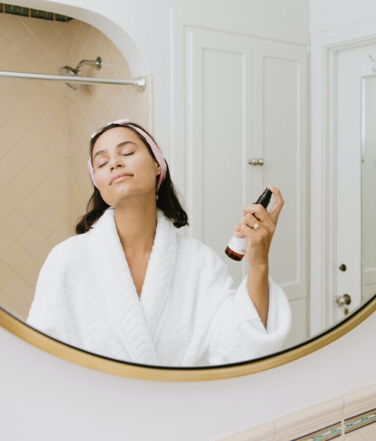 woman in white bathrobe holding smartphone