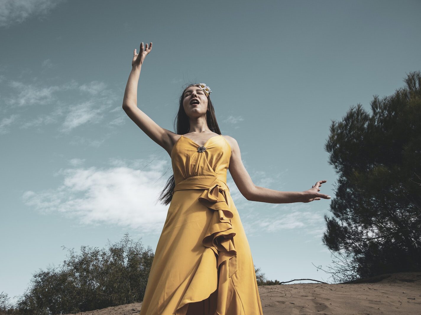Woman in Yellow Sleeveless Dress Standing on Brown Sand