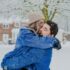 man and woman hugging on snow field