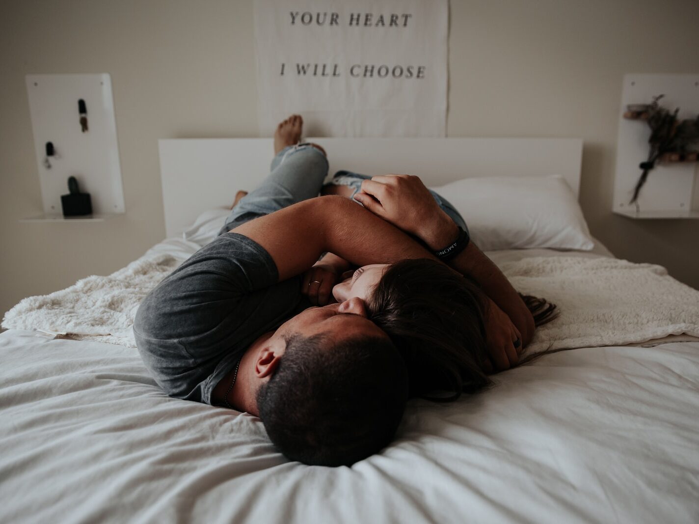 A man and woman cuddling together in bed.