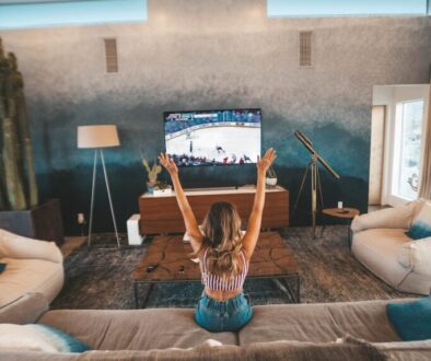 woman sitting on brown sofa watching TV