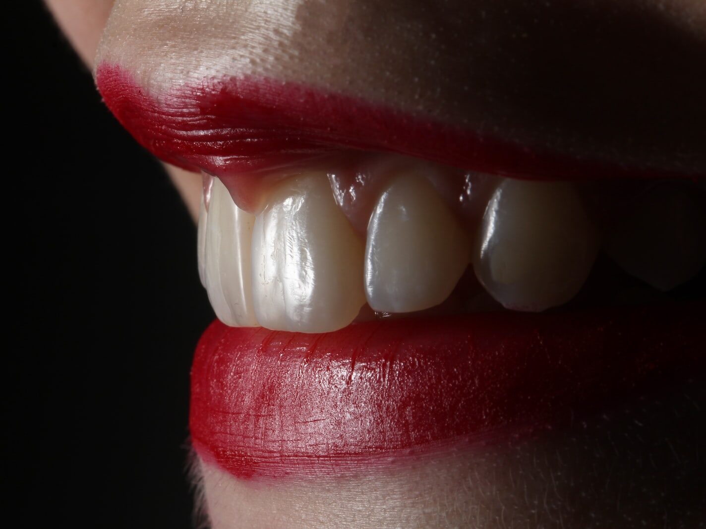 person with red lipstick and white pearl earrings