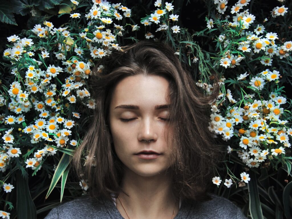 woman closing her eyes on white flower