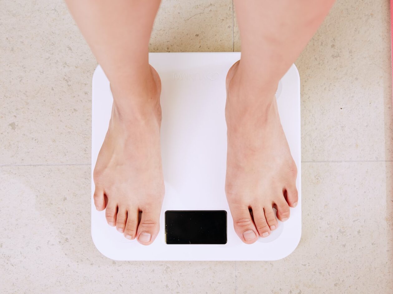 person standing on white digital bathroom scale