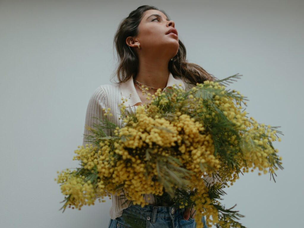 Beautiful Woman Looking Up Holding Yellow Flowers