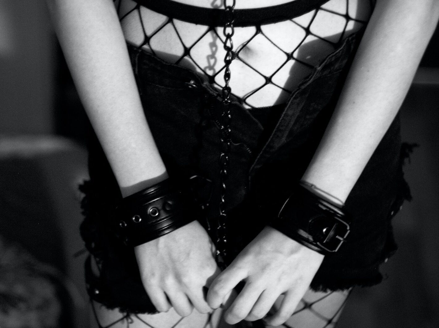 grayscale photo of woman wearing shorts and holding chain