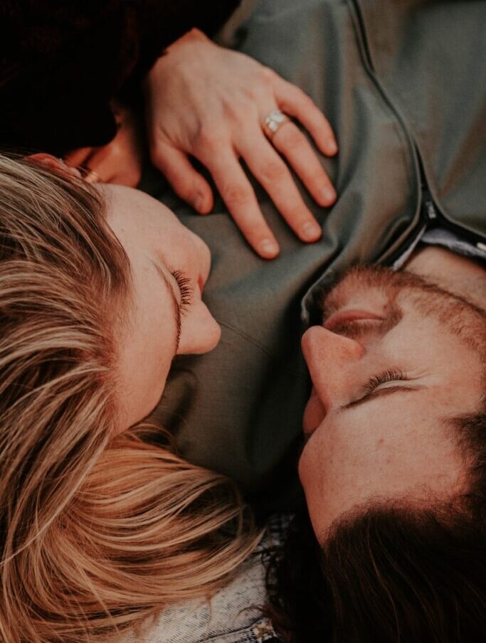 a woman stares into a man's eyes lovingly