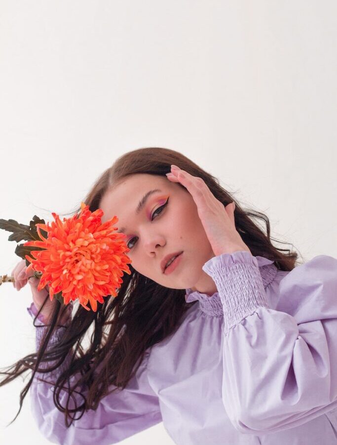 Dreamy woman with flower in studio