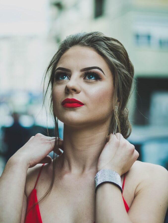 woman wearing red spaghetti strap looking upward