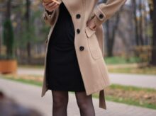 woman in brown coat standing on road during daytime