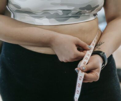 Plump woman in sportswear with measuring tape