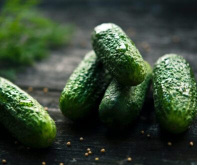 3 green cucumbers on black wooden table