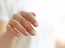 persons hand with white manicure