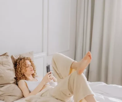 Woman Lying on Bed While Using a Cellphone
