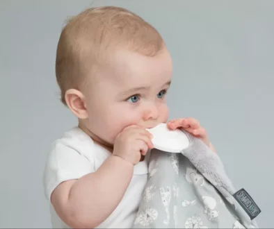 a baby is holding a napkin in his mouth