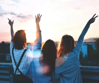photo of three women lifting there hands 