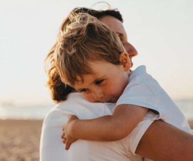 boy hugging woman during daytime